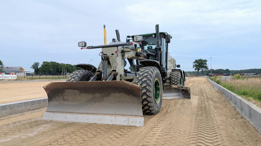A bulldozer leveling a road in Werlte, Niedersachsen, Germany under a clear sky.