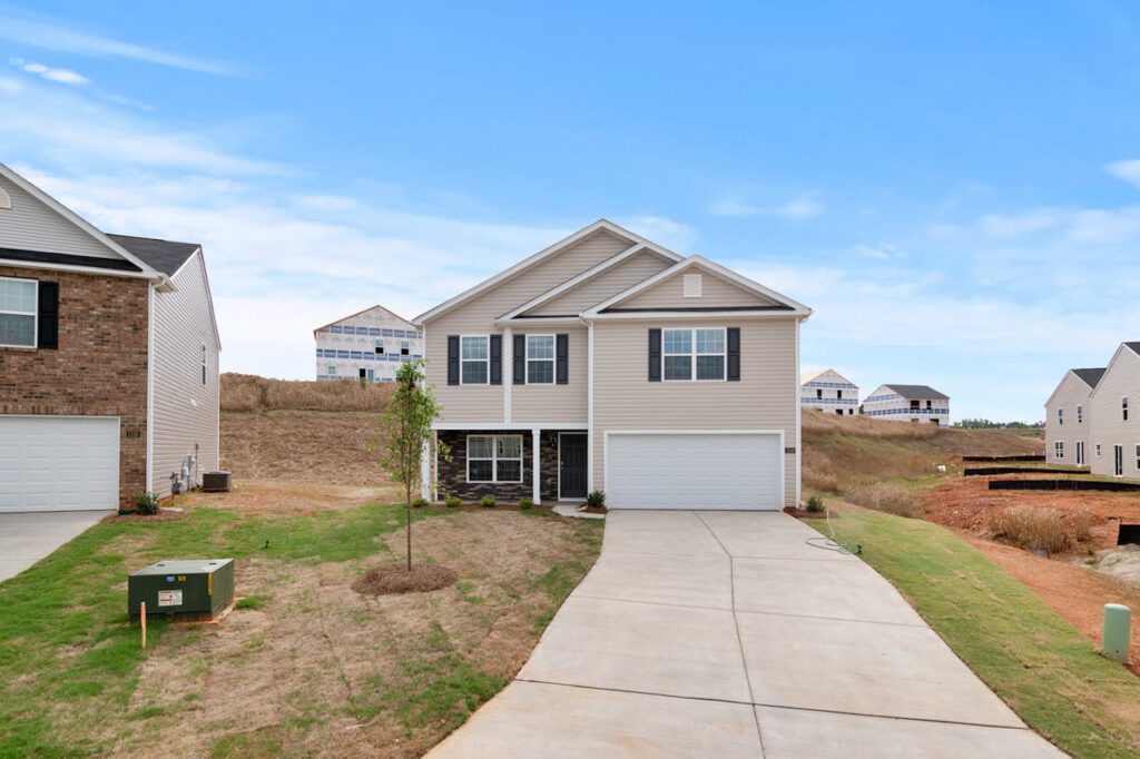 Newly constructed suburban home with spacious driveway and developing neighborhood.